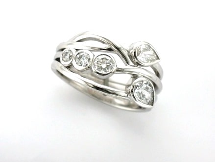 Anya is a Bespoke Diamond Ring designed as a Signature Brook Wave Engagement Ring set with Pear Shape Diamonds &  tapering Brilliant Cut Diamonds as a Triple Wave Ring.   