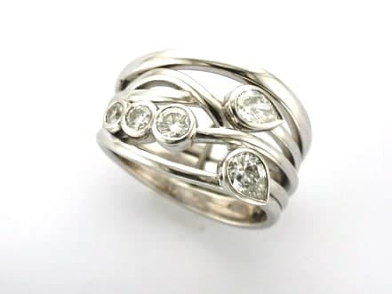 Anya is a Bespoke Diamond Ring designed as a Signature Brook Wave Engagement Ring set with Pear Shape Diamonds &  tapering Brilliant Cut Diamonds as a Triple Wave Ring.   