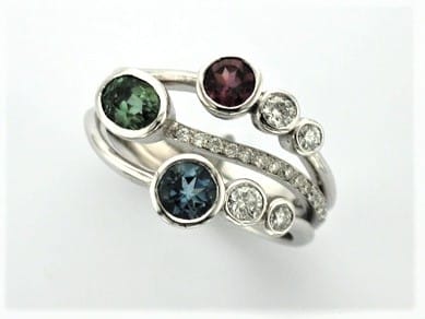 Signature Brook Wave Ring Designed with Garnet, Aquamarine, Tourmaline & Diamonds as one of our Family Rings with Birthstones.     The Gemstones were chosen to compliment each other's muted tones with tapering Brilliant Cut Diamonds & Pave set Diamonds added for sparkle.