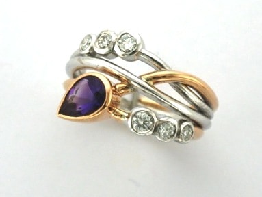 Signature Brook Wave Ring Designed with Pear Shape Amethyst & Tapering Brilliant Cut Diamonds as a triple wave, Right Hand Ring. Zoe Bespoke Diamond Ring was custom made in 18ct Rose & White Gold to celebrate February birthdays for two little girls.