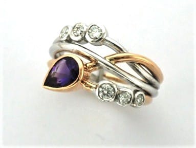 Signature Brook Wave Ring Designed with Pear Shape Amethyst & Tapering Brilliant Cut Diamonds as a triple wave, Right Hand Ring. Zoe Bespoke Diamond Ring was custom made in 18ct Rose & White Gold to celebrate February birthdays for two little girls.
